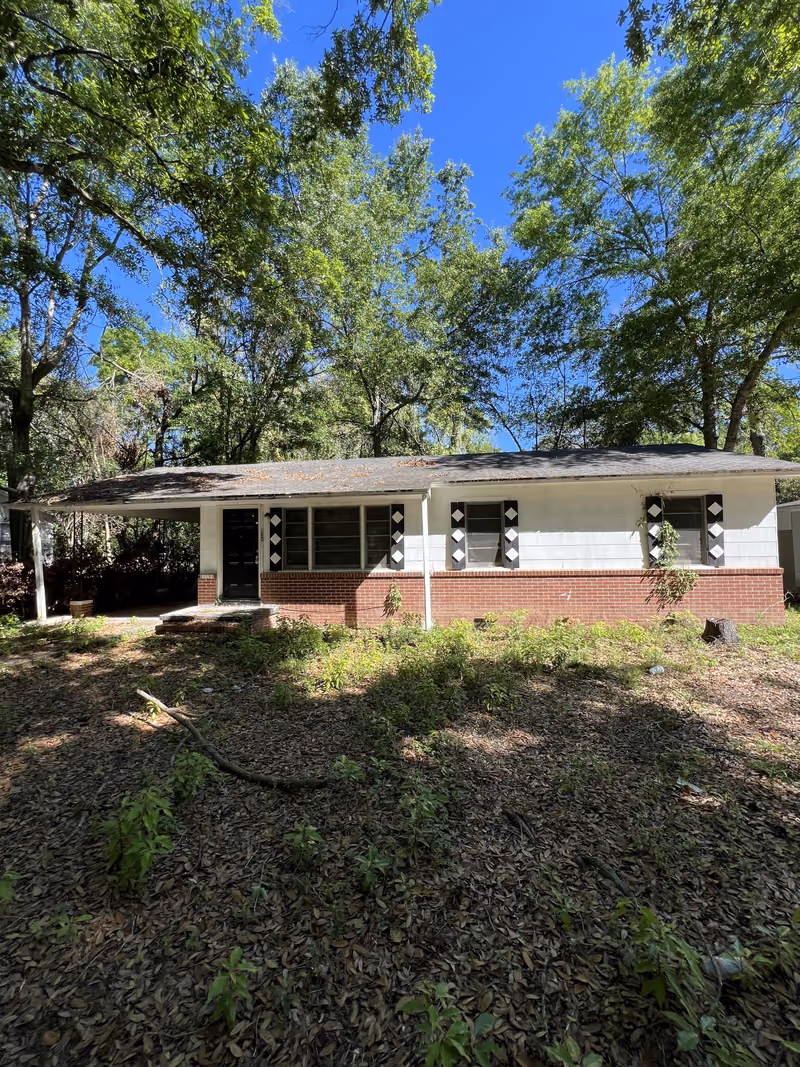 White block house with black diamond shutters and carport, as-is condition, South Georgia